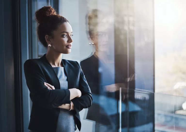 Femme professionnelle regardant par la fenêtre avec confiance
