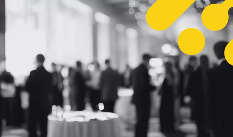 Personnes rassemblées lors d’un gala professionnel, en tenue de soirée, avec des motifs graphiques jaunes de la marque Humance au premier plan.