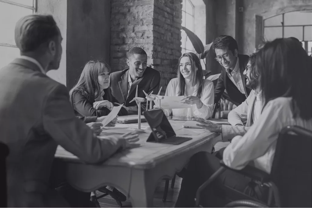 Équipe diversifiée en pleine séance de travail collaborative autour d’une table, dans une ambiance dynamique et conviviale.